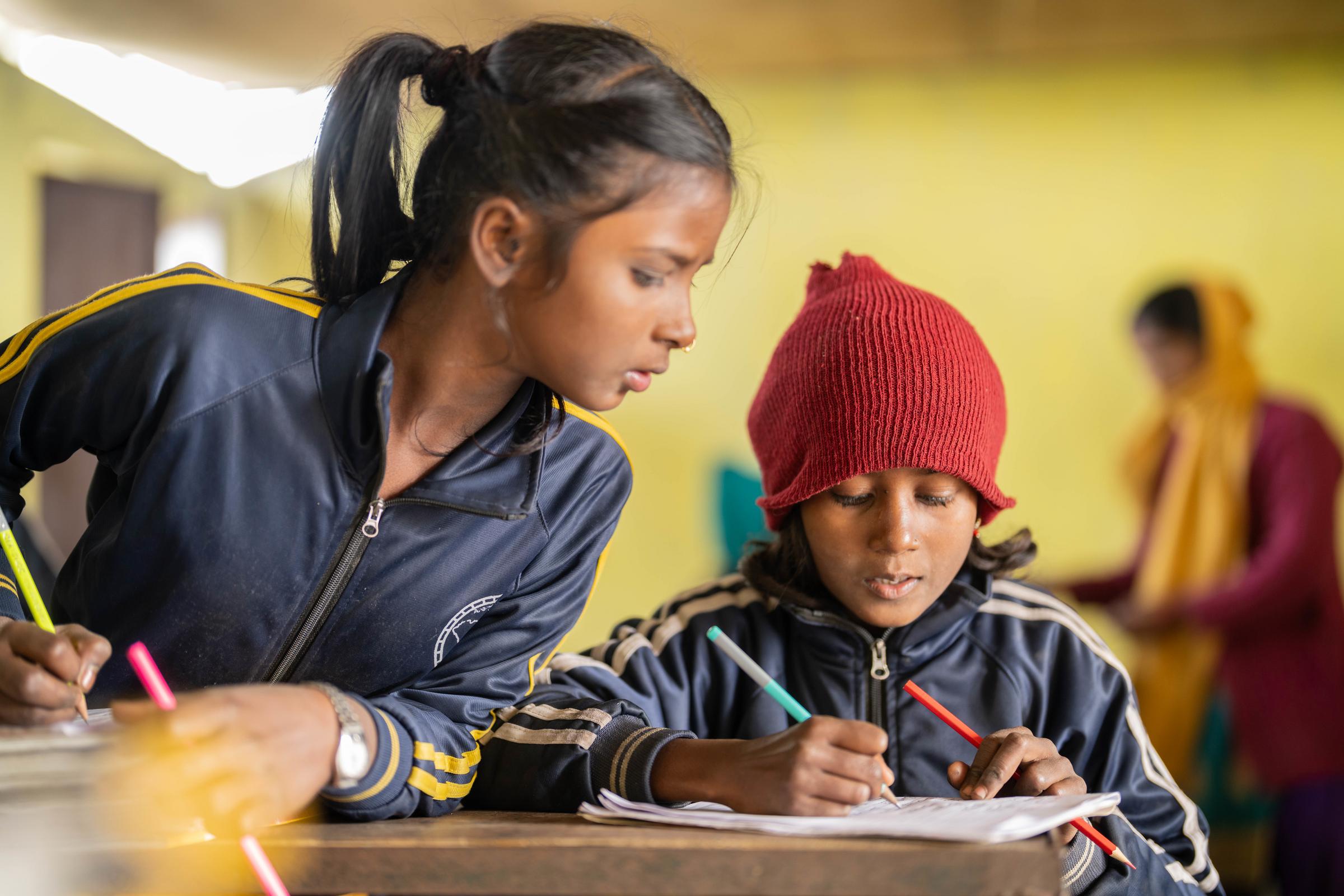 Zwei Mädchen sitzen am Tisch und schreiben. Ein Mädchen schaut bei dem anderen ab (Quelle: Jakob Studnar) Zwei Mädchen sitzen am Tisch und schreiben. Ein Mädchen schaut bei dem anderen ab (Quelle: Jakob Studnar)