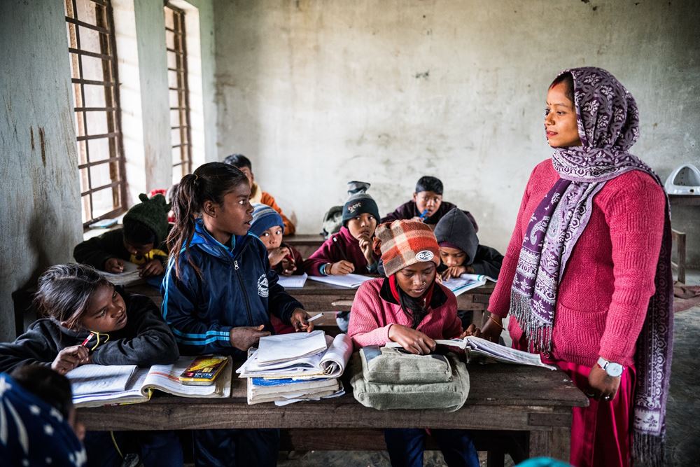 Gamya steht im Klassenzimmer und spricht mit ihrer Lehrerin. Wenn Gamya groß ist, möchte sie Sozialarbeiterin werden, um anderen Kindern den Weg aus der Kinderarbeit zu zeigen. (Foto: Martin Bondzio) Gamya steht im Klassenzimmer und spricht mit ihrer Lehrerin. Wenn Gamya groß ist, möchte sie Sozialarbeiterin werden, um anderen Kindern den Weg aus der Kinderarbeit zu zeigen. (Foto: Martin Bondzio)