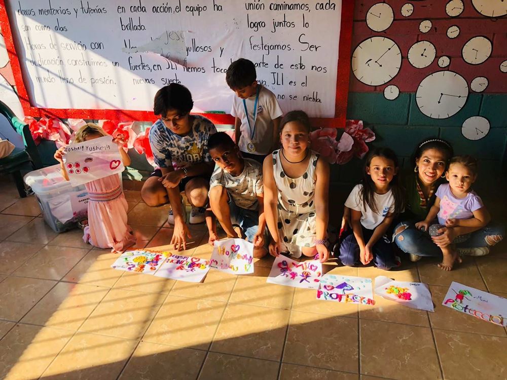 Kinder im Projekt sitzen vor einer Tafel und präsentieren selbst gestaltete Plakate (Quelle: ASJ Honduras/CASM Honduras) Kinder im Projekt sitzen vor einer Tafel und präsentieren selbst gestaltete Plakate (Quelle: ASJ Honduras/CASM Honduras)