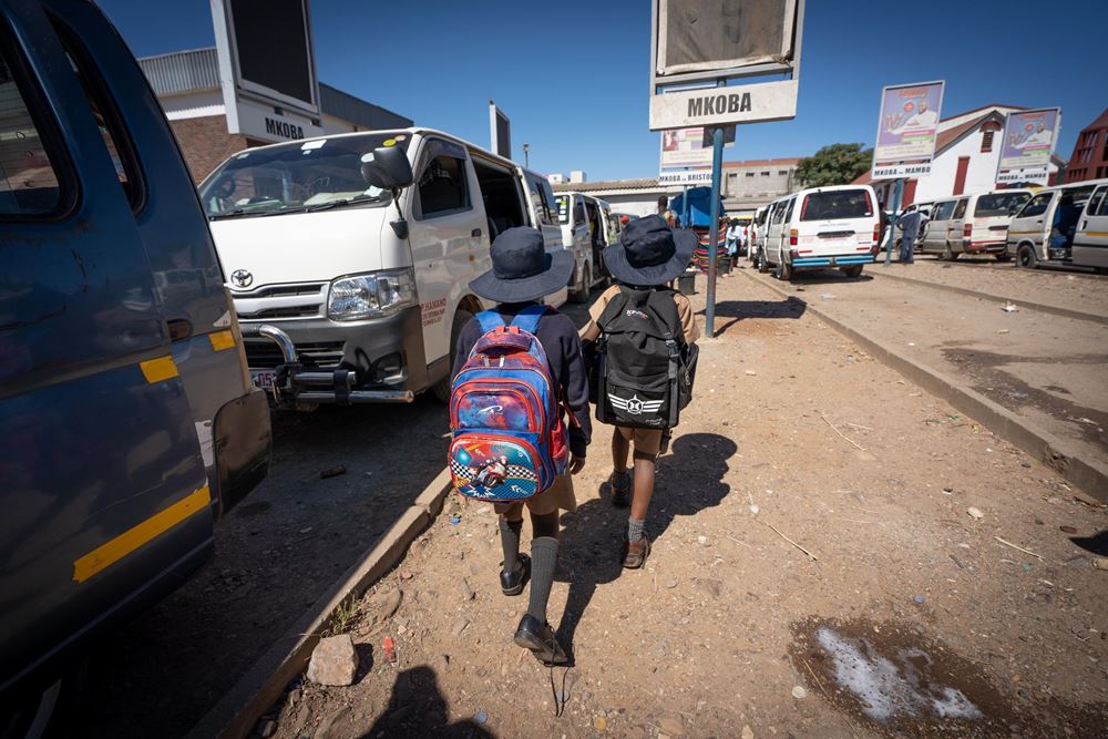 Zwei Kinder laufen auf einem Weg zwischen Kleinbussen, die dicht an dicht stehen und die Wege dazwischen sind nur sehr schmal. Für Kinder ist das extrem gefährlich. (Foto: Christian Nusch) Zwei Kinder laufen auf einem Weg zwischen Kleinbussen, die dicht an dicht stehen und die Wege dazwischen sind nur sehr schmal. Für Kinder ist das extrem gefährlich. (Foto: Christian Nusch)