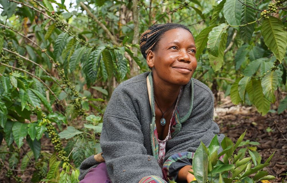 Eine Frau aus Uganda steht auf ihrem Feld und lächelt. (Quelle: Ludwig Grunewald) Eine Frau aus Uganda steht auf ihrem Feld und lächelt. (Quelle: Ludwig Grunewald)